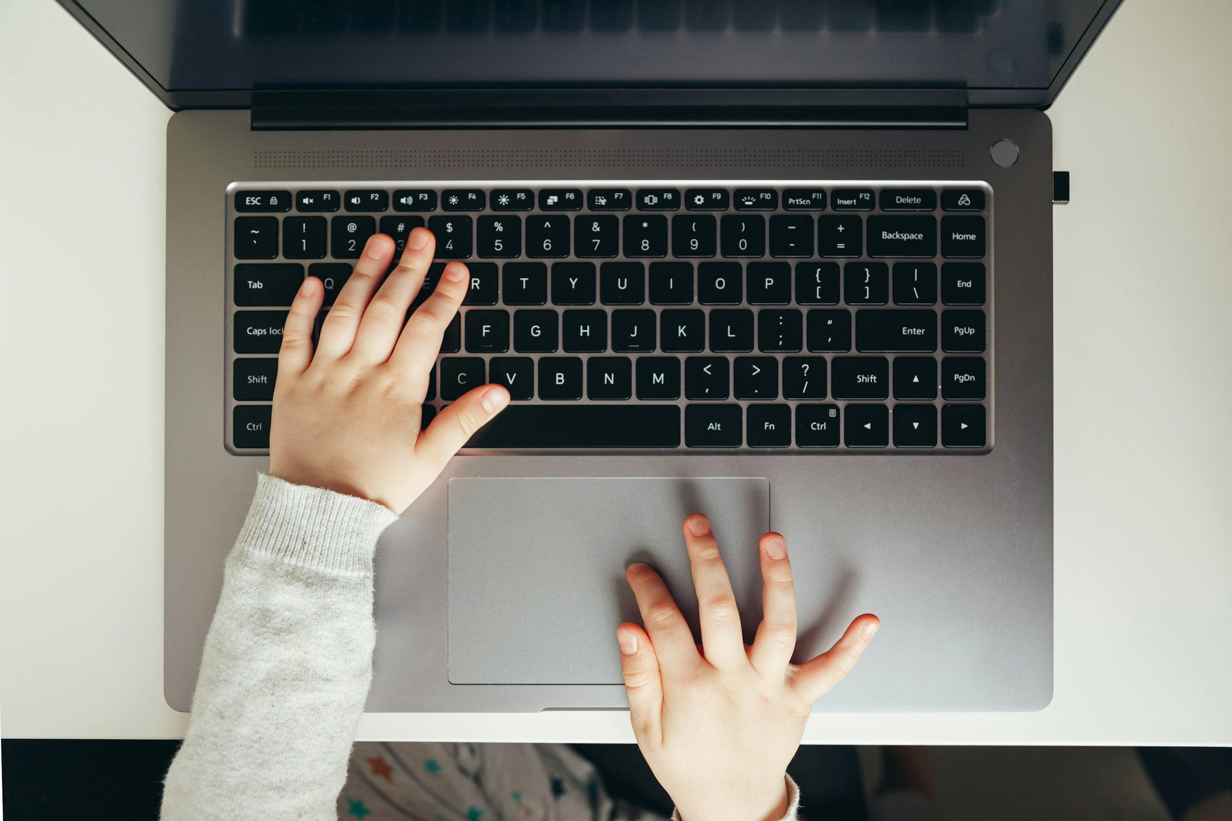 A child working through practice questions on a laptop at home