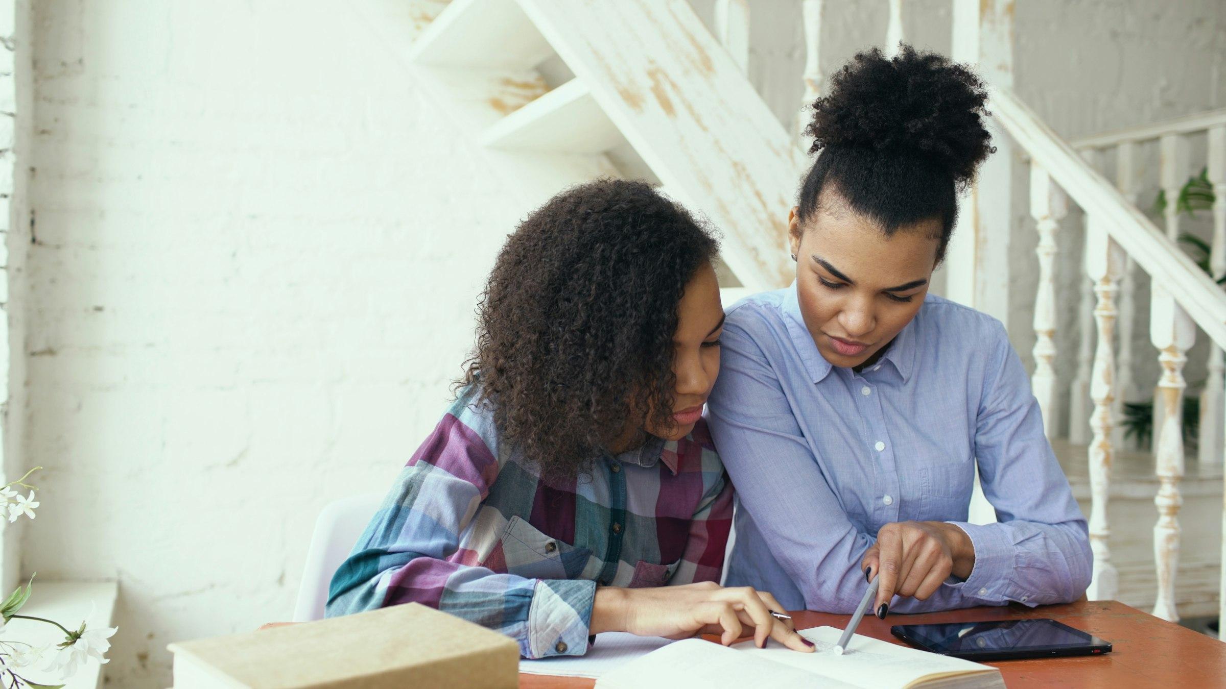 A parent and child looking at learning progress together