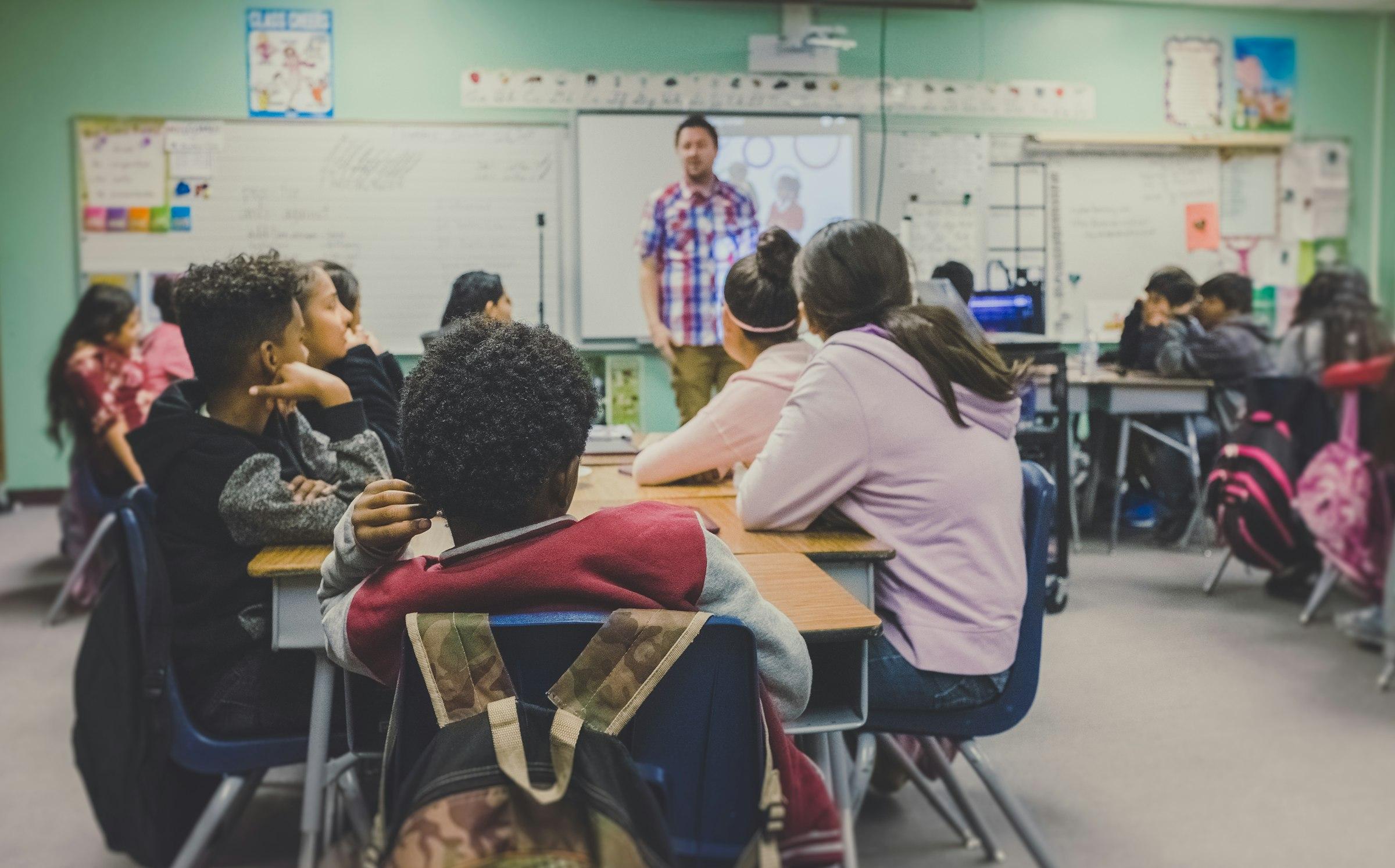 A teacher helping a small group of students in a classroom